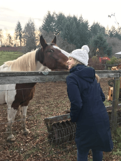 Kristi happily being kissed by a horse